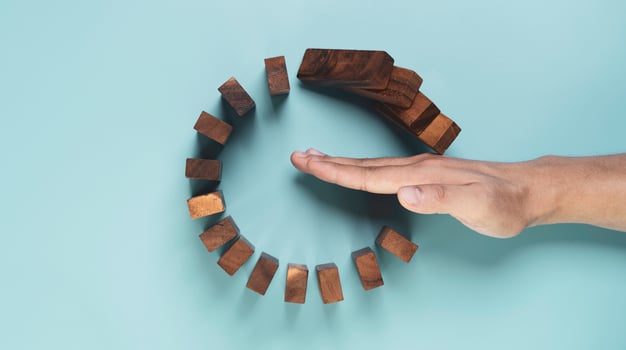 Top view and flat lay design of Businessman use gesture to stop wooden domino circle falling for insurance assurance and risk management concept. photo