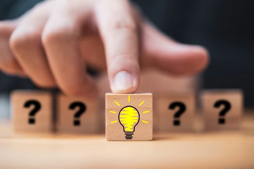 Hand pushing lightbulb drawing which print screen on wooden cube block among human and question mark for creative thinking idea and problem solving concept. photo