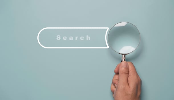 Hand holding magnifier glass with search bar icon for SEO or Search Engine Optimisation wording concept. photo