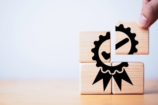 Closeup of hand putting to assemble quality assurance icon which print screen on wooden cube block for quality guarantee and ISO certificate of product and service concept. photo