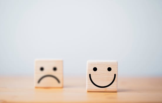Focus of Smile face and defocus of sad face on wooden block cube for positive mindset selection concept. photo