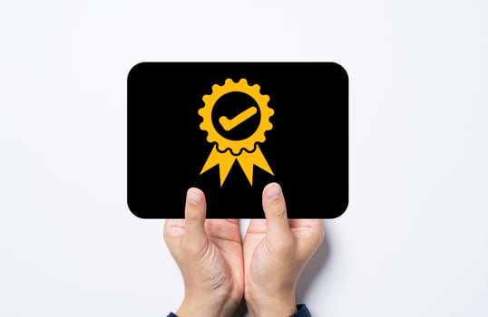 Hand holding black card with golden quality assurance and guarantee certificate sign. photo