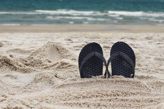 Flip flops in the beach. Slippers embed in sand beach. photo