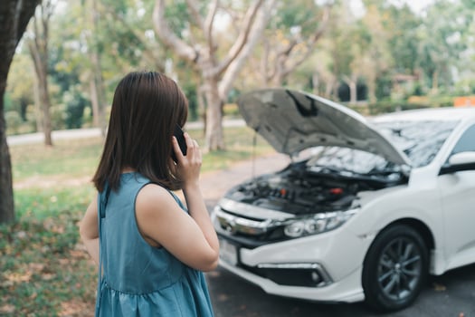 Asian woman calling garage after car breaks down. woman opening car hood and call to insurance or someone to help after the car breaks down, park on the side of the road. Transportation concept. photo