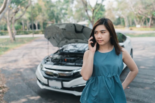 Asian woman calling garage after car breaks down. woman opening car hood and call to insurance or someone to help after the car breaks down, park on the side of the road. Transportation concept. photo