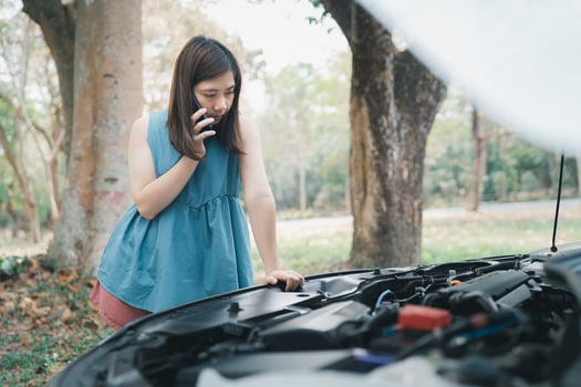 Asian woman calling garage after car breaks down. woman opening car hood and call to insurance or someone to help after the car breaks down, park on the side of the road. Transportation concept. photo