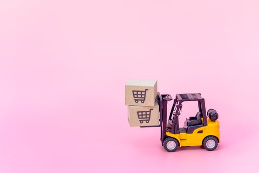 Logistics, and delivery service - Forklift model and paper cartons or parcel with a shopping cart logo on Pink background. Shopping service on The online web and offers home delivery. photo