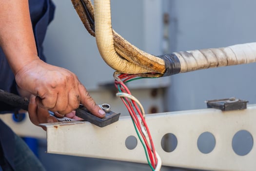 Technician man using a wrench fixing modern air conditioning system, Maintenance and repair concept photo