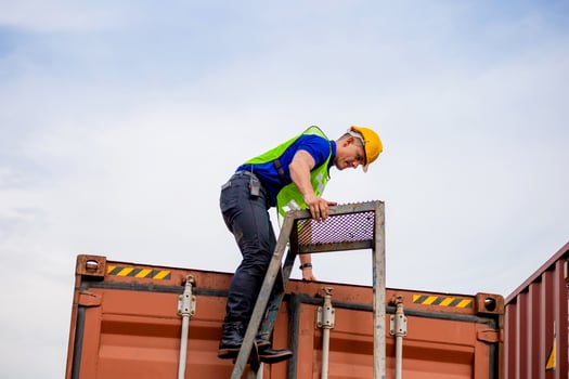 Worker go up climbing the ladder to the container photo