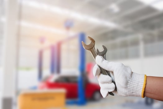 Car mechanic holding wrench at the car repair garage photo
