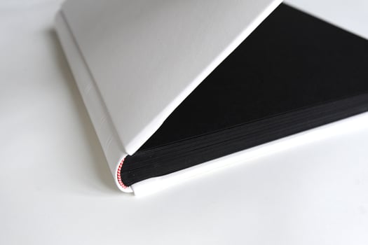 Big photobook lay on wooden table white with black pages photo