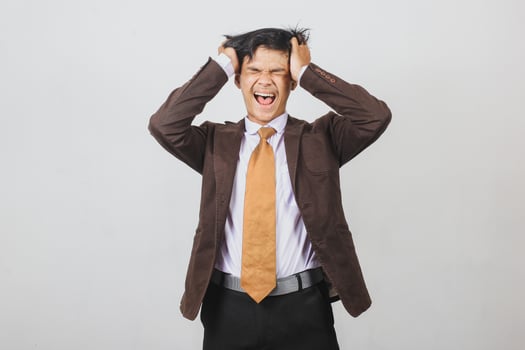 Stressed Asian young businessman having headache and feel upset photo