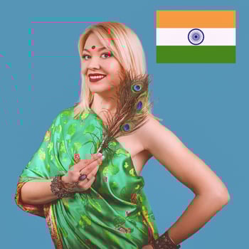 beautiful smiling attractive european blonde woman in Indian national dress with peacock feather, bracelets, accessories. photo