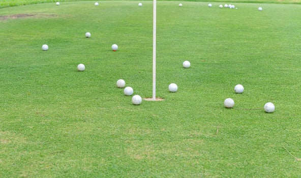 Golf holes and golf balls in the grass photo