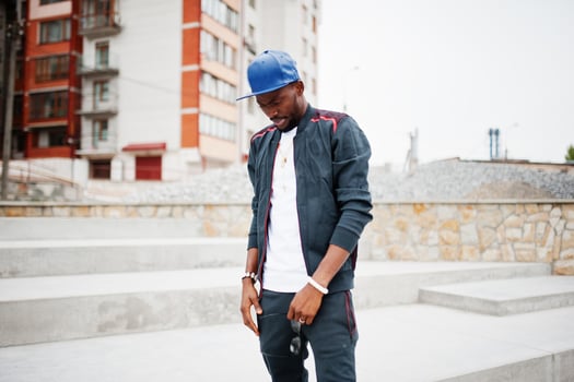 Portrait of stylish african american man on sportswear, cap and glasses. Black men model street fashion. photo