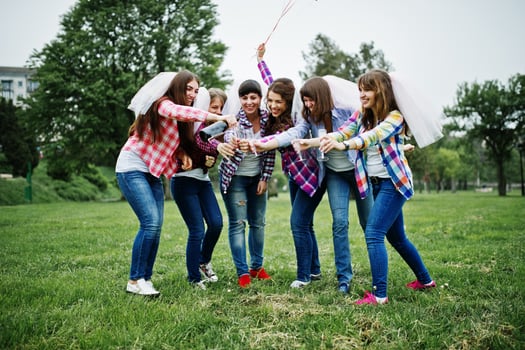 Six girls at checkered shirts drinking champagne on hen party. Group of happy girls. photo