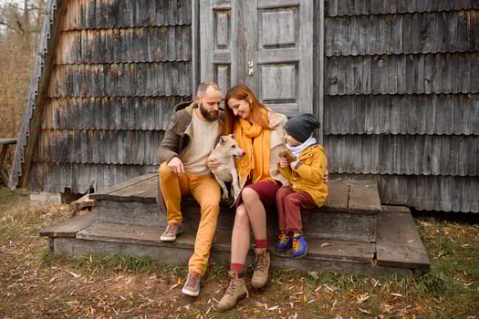 a happy family sits on the steps in front of the entrance to the house. photo
