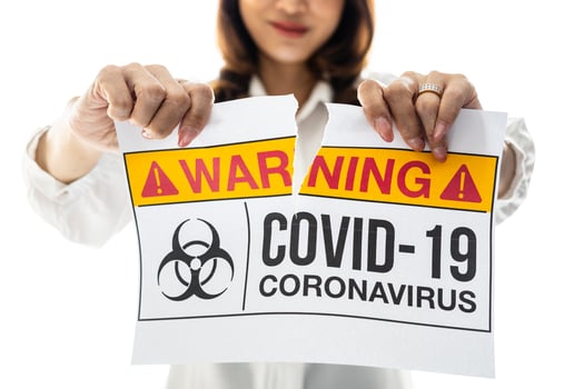 Woman holding and tearing paper with Covid-19 coronavirus warning words. The idea or concept for the ending, happiness, free, and wellness after finishing and recovered from Coronarivus photo