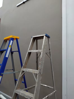 A pair of steel stairs. Steel stairs for construction. A pair of steel stairs stand beside a cement wall. photo