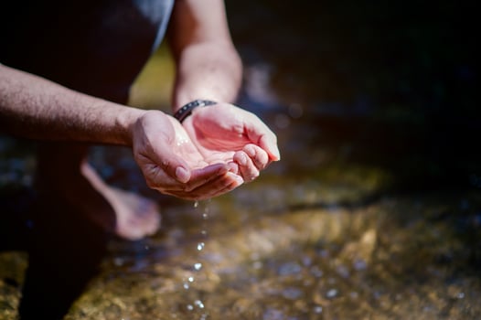 Hands and water flowing from natural waterfalls Water concept from natural waterfall photo