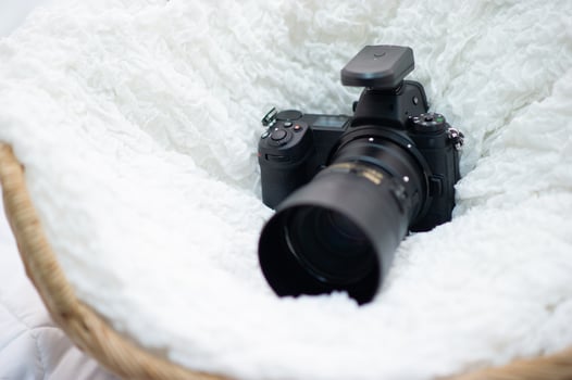 The black camera is well placed in a white cloth. photo