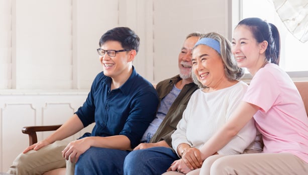 Cheerful Asian family watching television in living room, Senior father mother and middle aged son and daughter sitting on sofa, Happiness family concepts photo