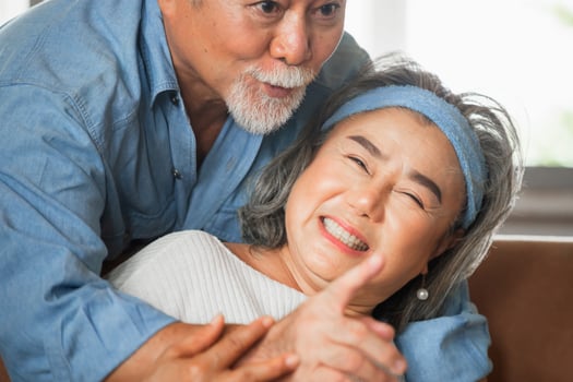 Close up portrait of happy senior asian couple hugging in living room photo