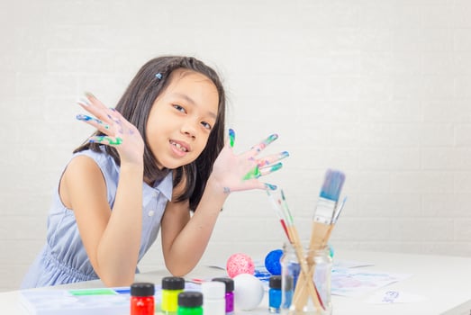 Cheerful little cute girl playing and learning with coloring the colors photo