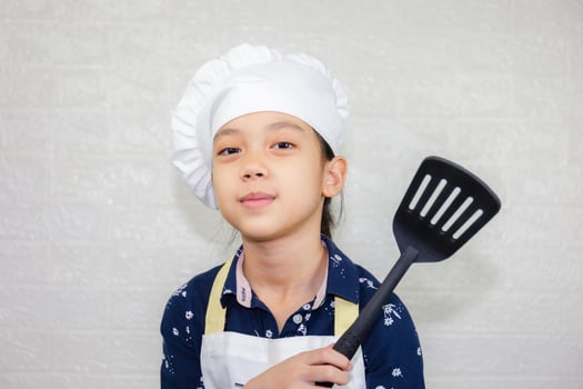 Dream careers concept, Portrait of Happy Kid chef looking at camera with blurred background photo