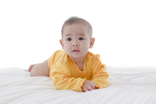 An Asian baby in a clean white bed. photo