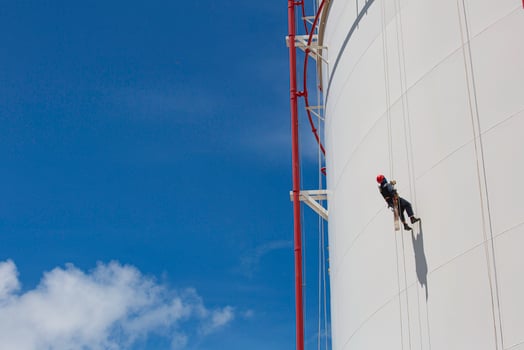 Male worker down height tank shell plate rope ladder  access safety inspection of thickness storage tank photo