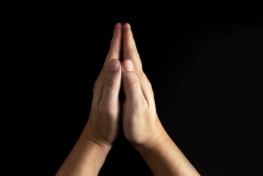The man whose hand is praying on the black background photo