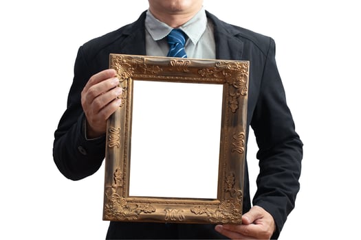 A blank diploma or a mockup certificate in the hand of a male employee wearing a black suit on white background with a clipping path. The vertical picture frame is empty. selective focus. photo