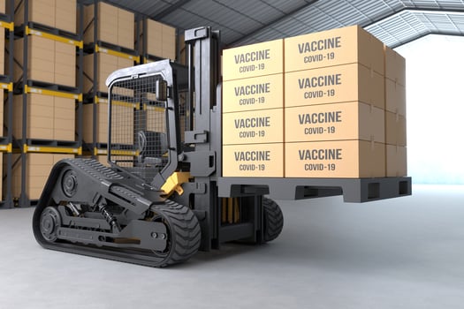 The forklift truck is lifting a pallet with packages containing COVID-19 vaccine photo