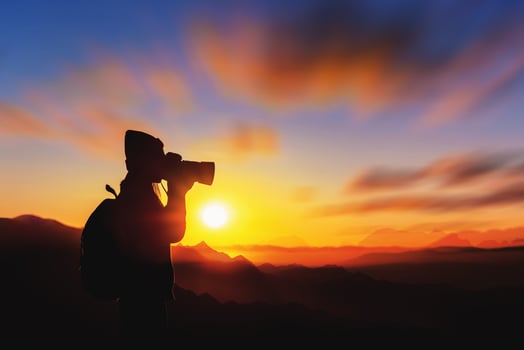 Woman tourists taking pictures on a mountain against the background of sunrise in the morning. photo