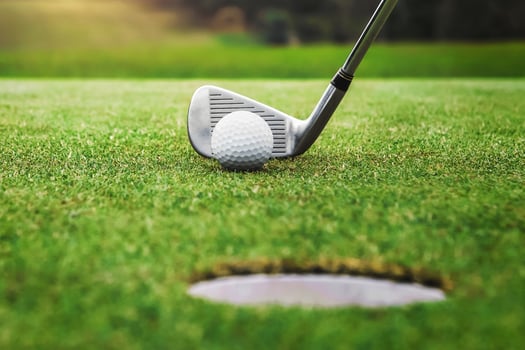 golf player putting golf ball into hole photo