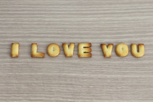 I LOVE YOU sentence arranged with cookies ABC on white oak wooden background for valentine's day. photo