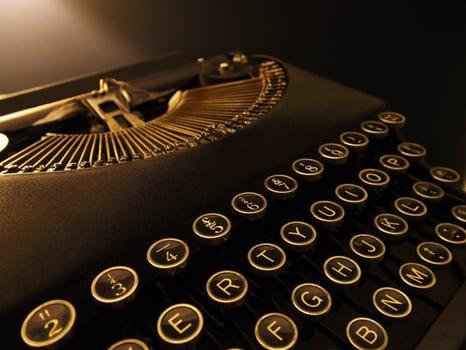Close Up Image of a Retro Vintage Typewriter, it has Beautiful Black and Gold Keys photo