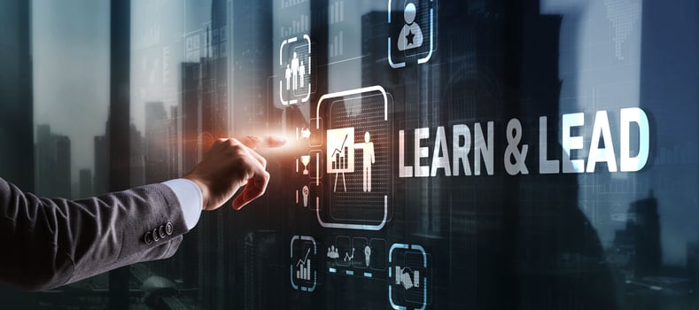 Learn and Lead. Businessman presses hand on the virtual screen inscription photo