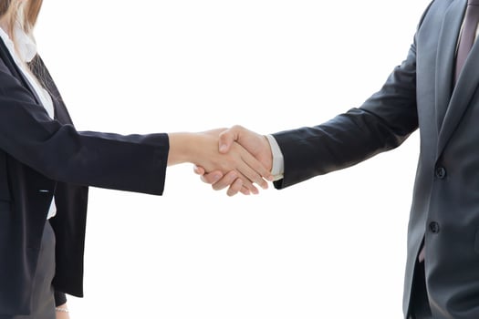 Two young business men and women are neatly dressed in a suit and tie, standing hand in hand, showing separate business symbols on a white background. photo