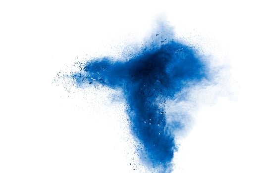 Abstract blue powder explosion on white background. Blue dust particles splash. photo