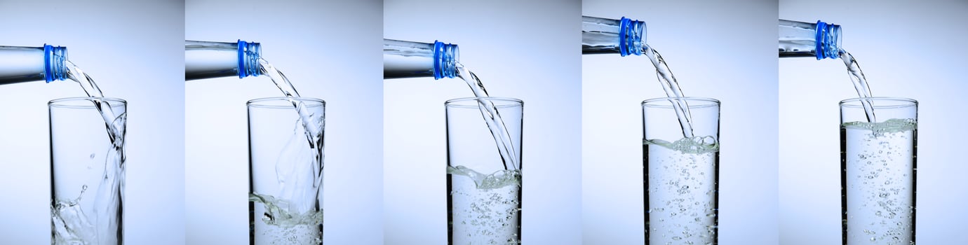 glass is filling up with water. water splash collection on white background. photo