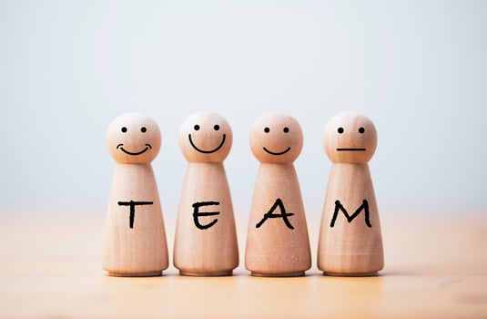 Wooden figures smile face with team wording on body for teamwork and business corporation concept. photo