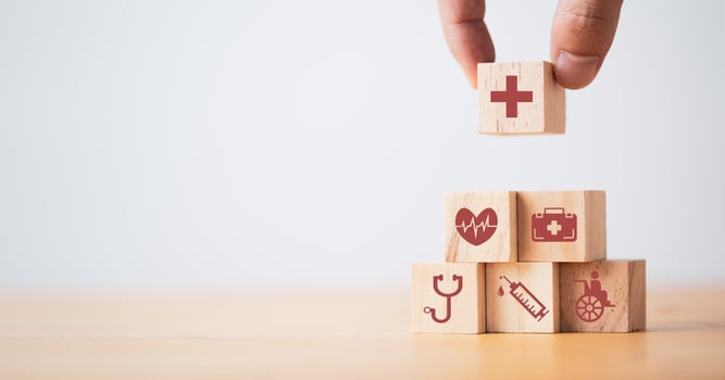 Doctor putting and stacking wooden block cube which print screen health care and medical icons for healthy and wellness concept. photo