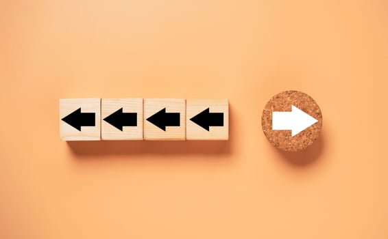 White arrow on circle wooden move on different direction with black arrow on cube for business and technology disruption concept. photo