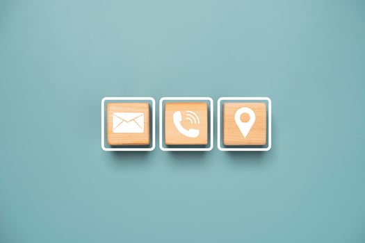White letter telephone and location icons print screen on wooden cube block for customer service contact concept. photo