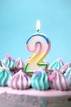 slow motion of burning candle on a birthday cake on light green background photo