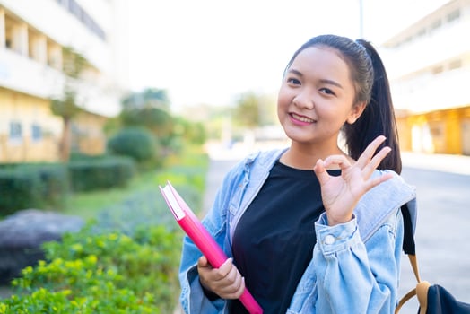 Happy student girl hold book and backpack at school, Asian girl. photo