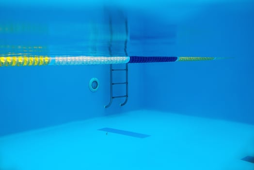 View of the swimming pool with metal ladder underwater photo