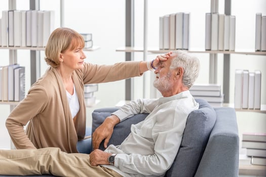Woman checking fever on forehead by hand, Elderly woman touches the forehead of old husband, Senior couple and happy family concepts photo